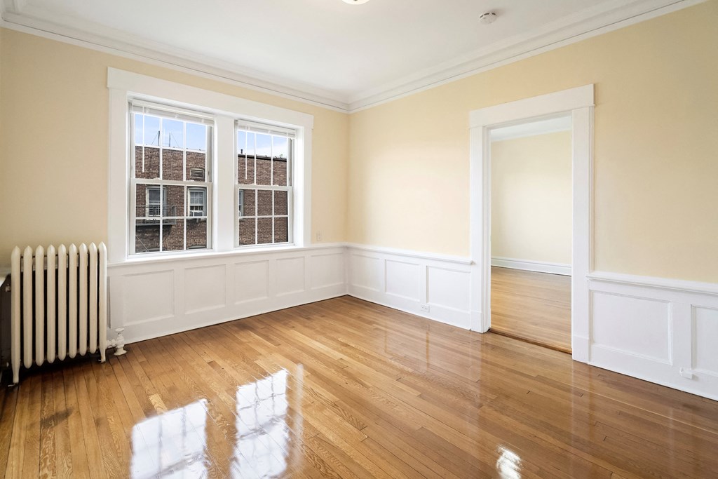an empty living room with white walls and wood floors