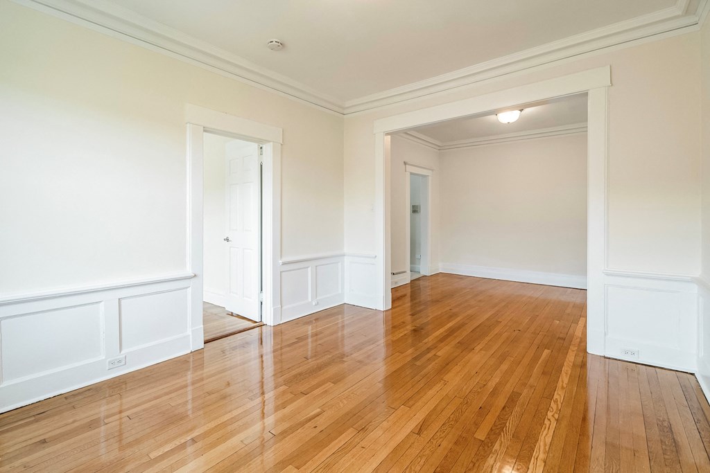 an empty living room with white walls and wood floors