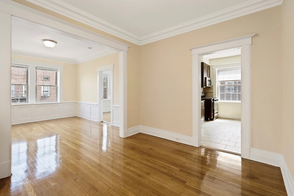 a living room with a hardwood floor and a doorway into a bedroom
