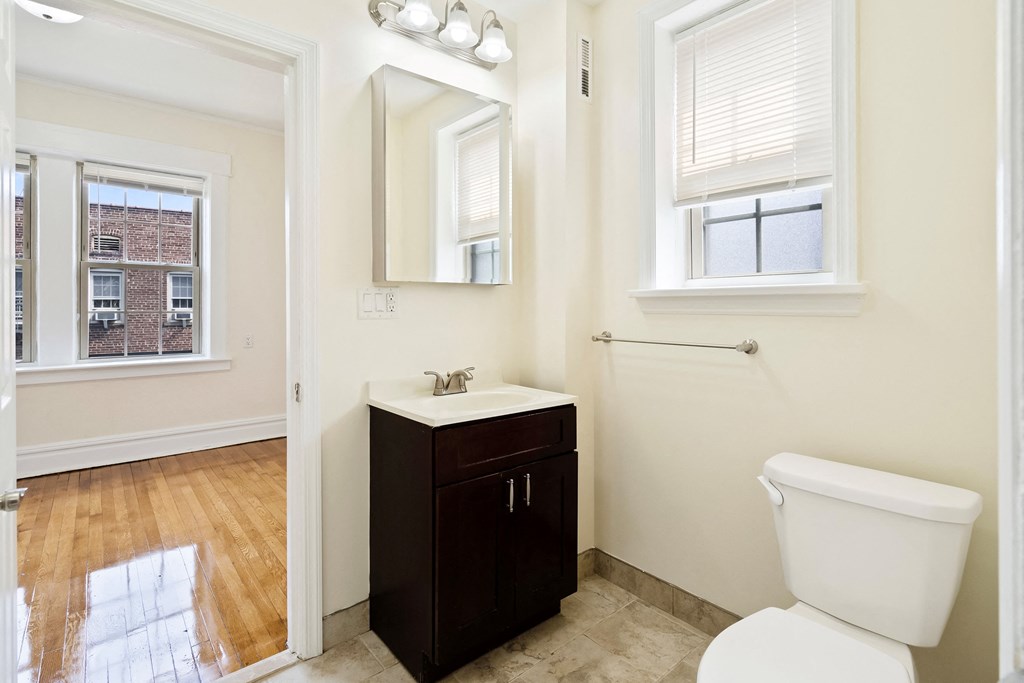 a bathroom with a toilet and a sink and a mirror