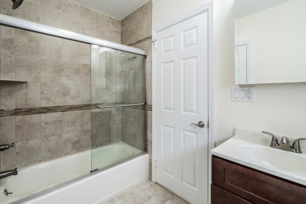a bathroom with a shower and a sink and a door