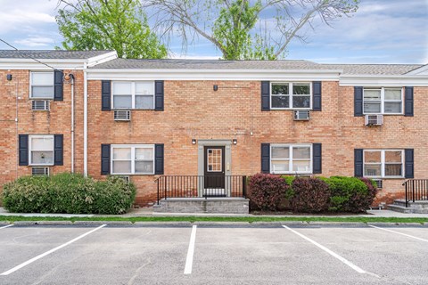 a brick house with a parking lot in front of it