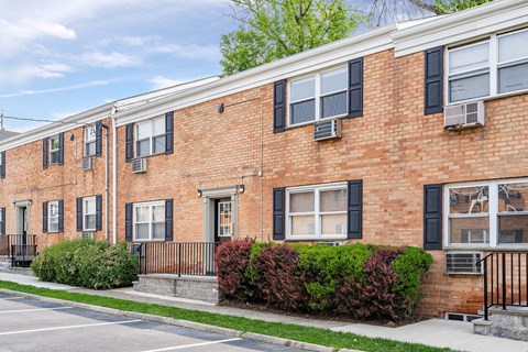 a brick apartment building with a sidewalk in front of it