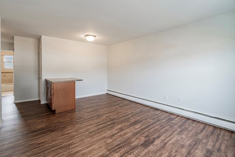 an empty living room with wood flooring and white walls