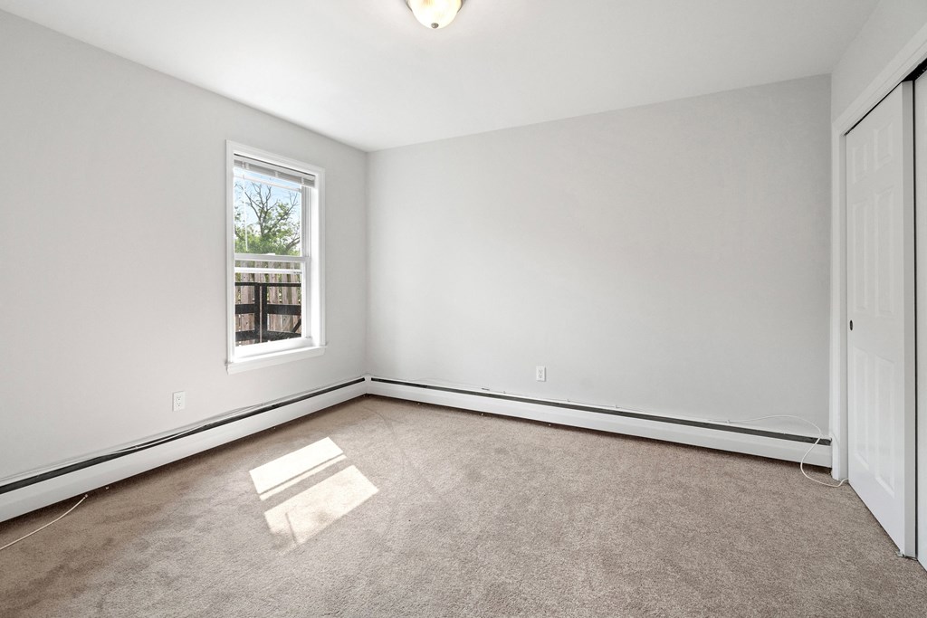 an empty room with a window and white walls