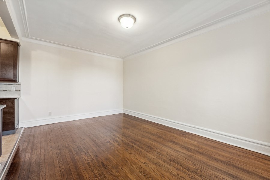 an empty living room with wood floors and white walls