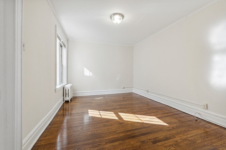 an empty room with wood floors and a window