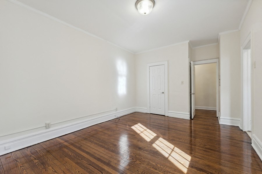 an empty living room with wood floors and white walls