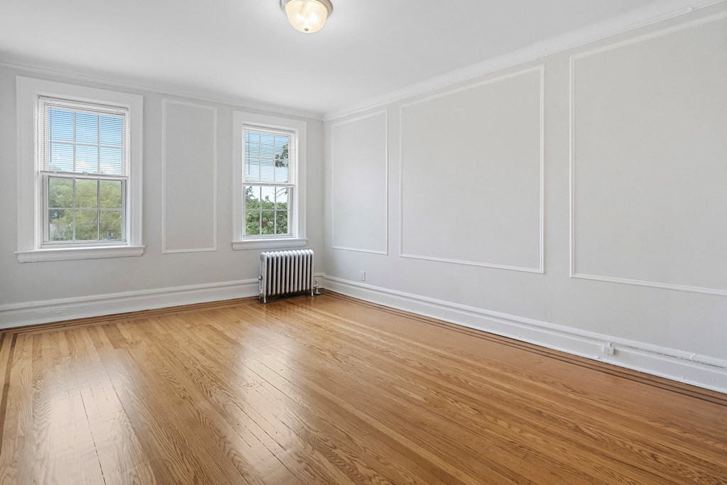 an empty living room with white walls and wood floors