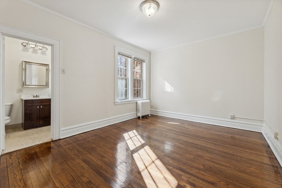 an empty living room with wood flooring and a window