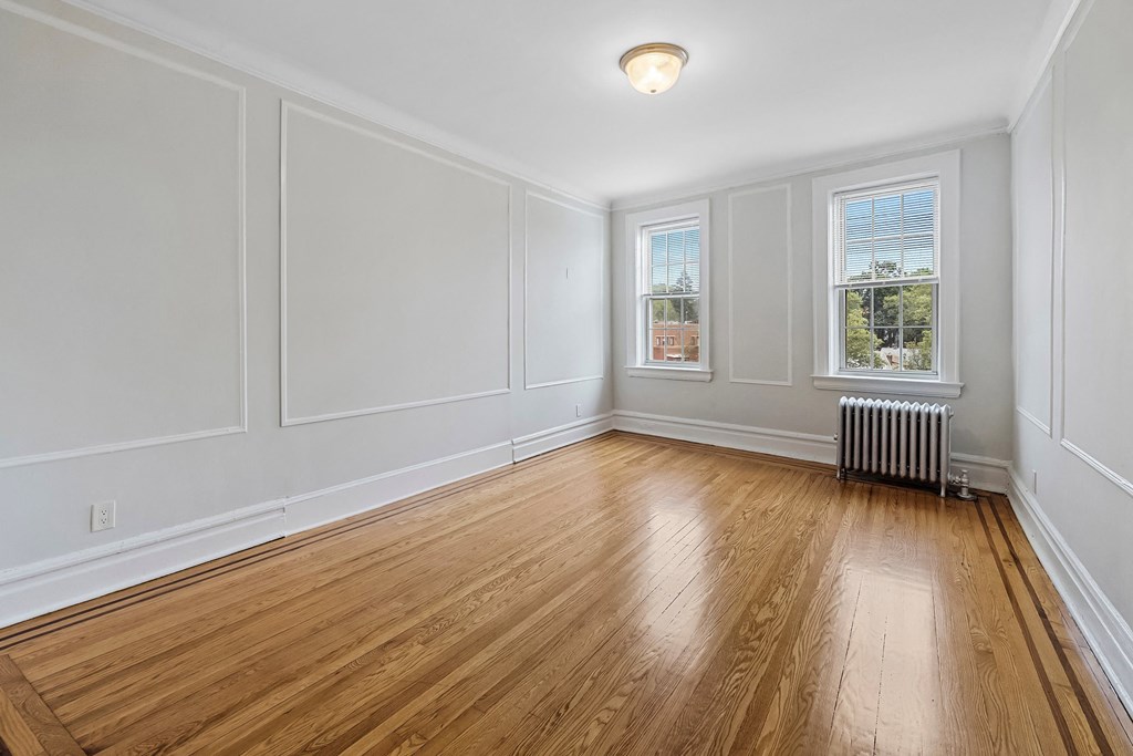 an empty living room with white walls and wood floors