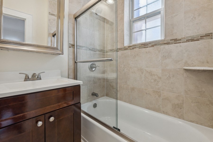 a bathroom with a shower and a sink and a bath tub