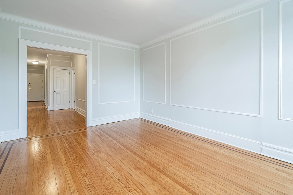 an empty living room with white walls and wooden floors