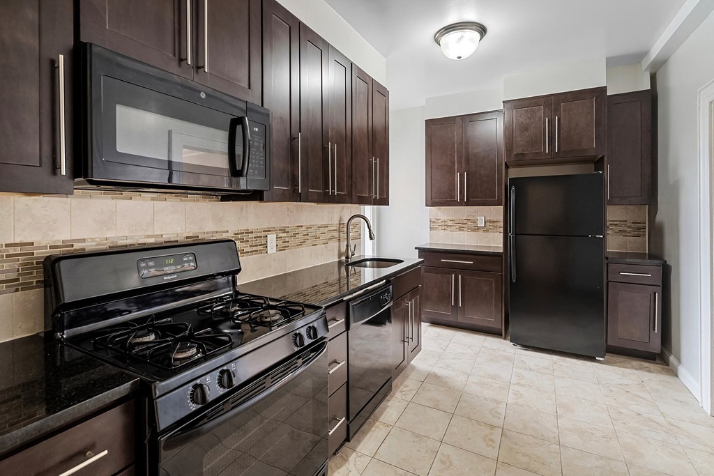 a kitchen with stainless steel appliances and dark wood cabinets