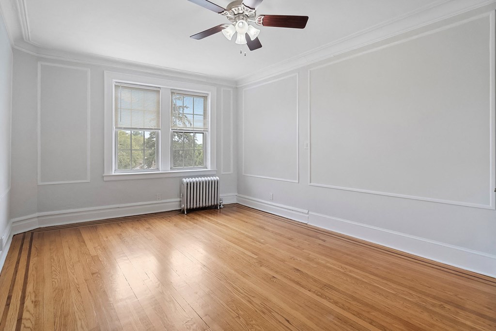 an empty living room with white walls and a ceiling fan