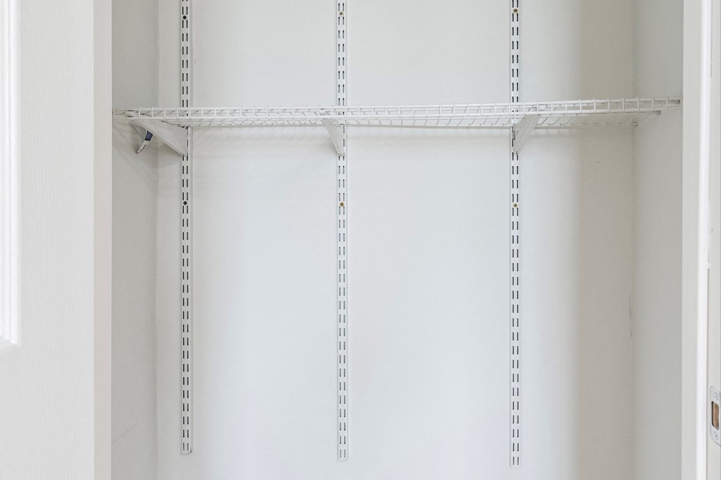 an empty shelf in a closet with measuring tapes