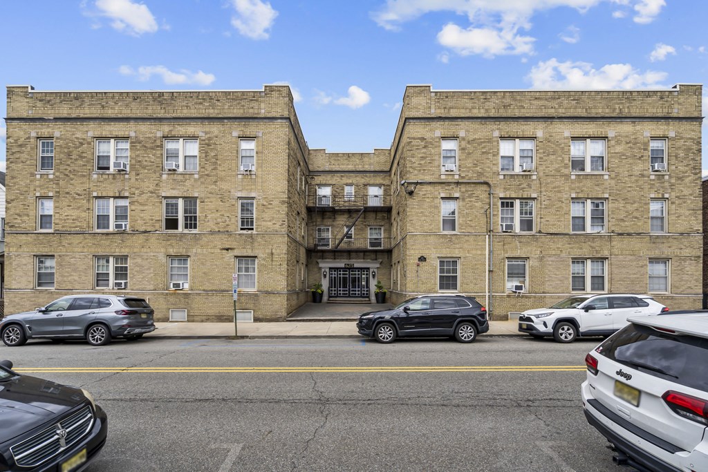 a large brick building with cars parked in front