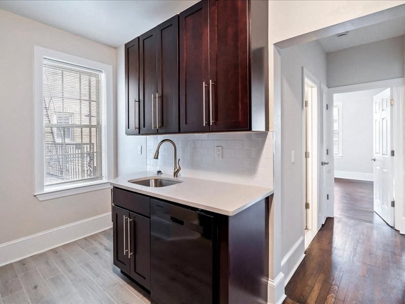 an empty kitchen with wooden cabinets and a sink