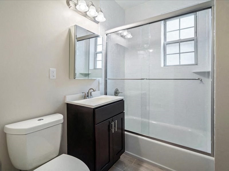 a bathroom with a toilet and a sink and a shower