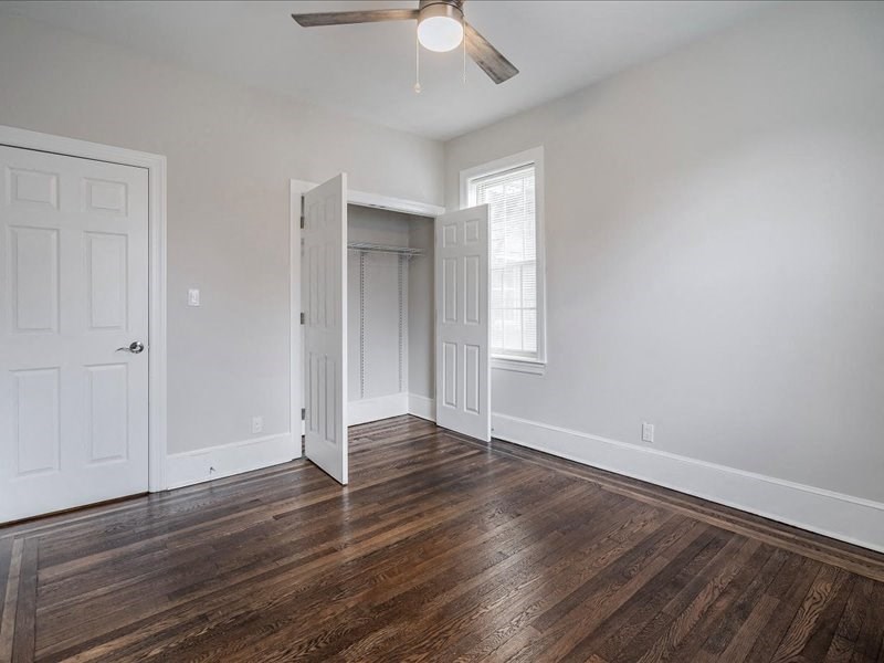 an empty living room with white walls and wood floors