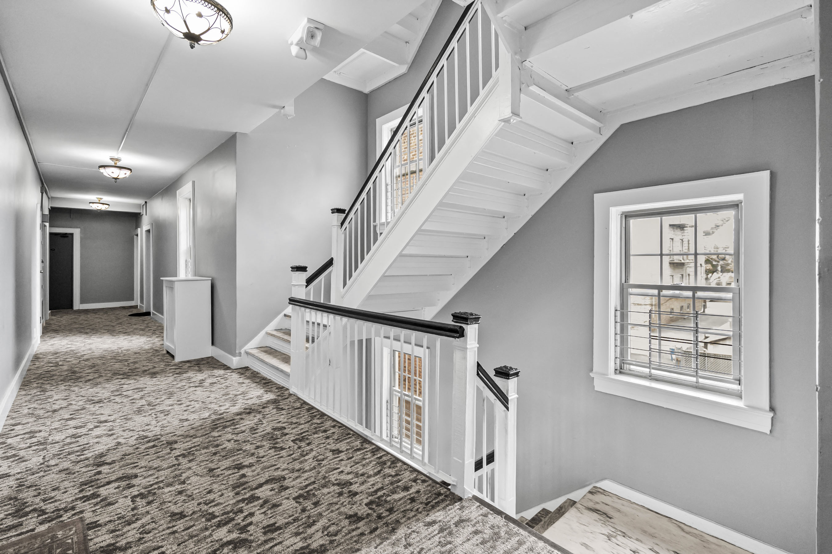 a long hallway with a staircase and a window