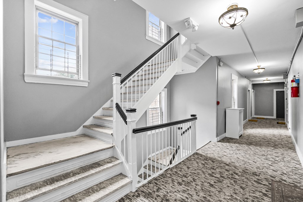 the entryway of a house with a staircase and a window