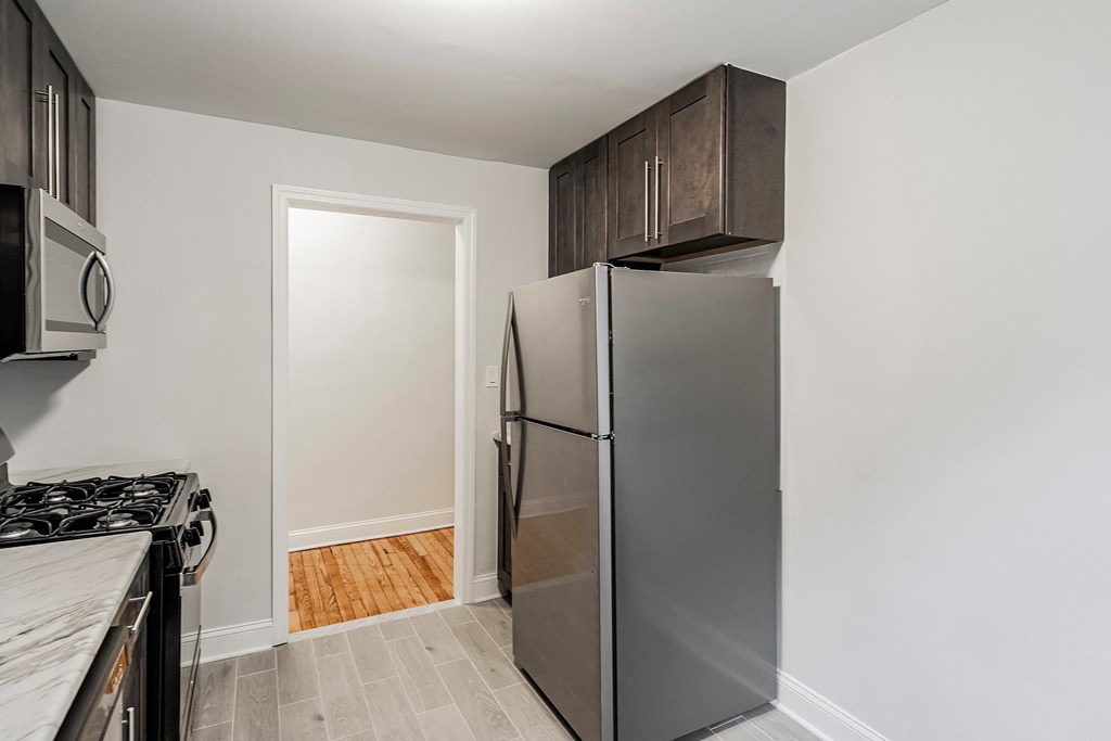 a kitchen with a refrigerator and a stove and a microwave