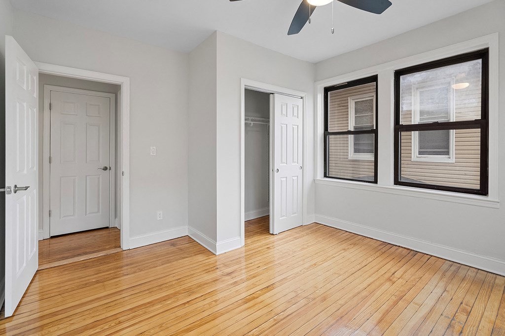 an empty living room with wood flooring and a window