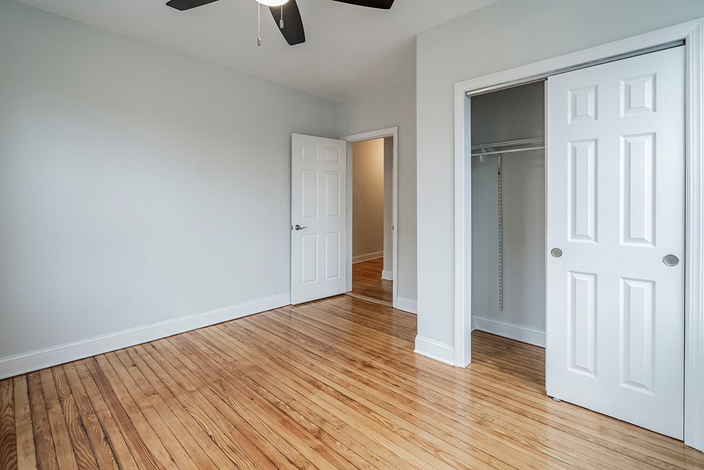 an empty living room with wood flooring and a closet