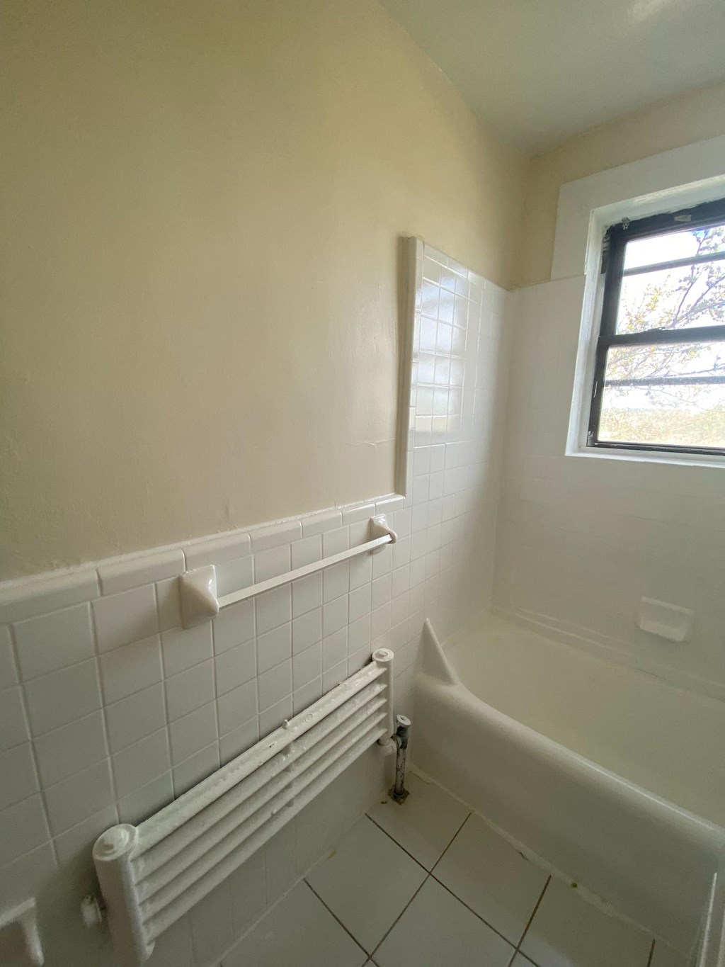 a small bathroom with a tub and a window