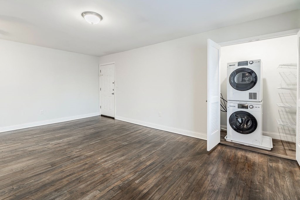 an empty living room with a washer and dryer in it