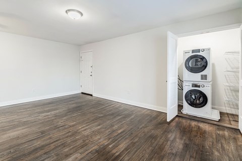 an empty living room with a washer and dryer in it
