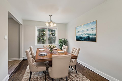 A dining room with a wooden table and chairs.
