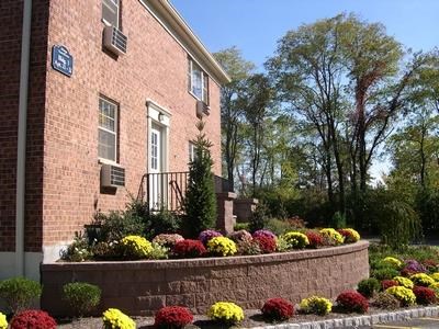 a brick building with a flower garden in front of it