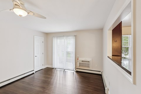 A room with a ceiling fan and a window with blinds.