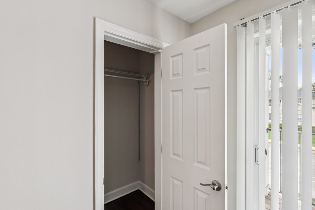 A white door is open to a small closet.