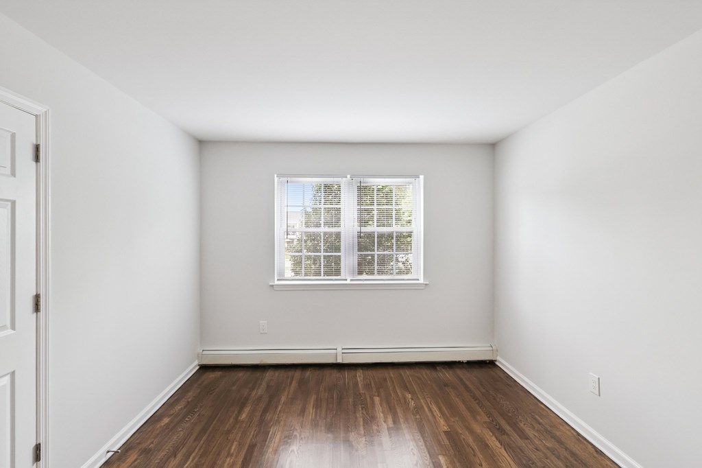 A room with a window and wooden floors.