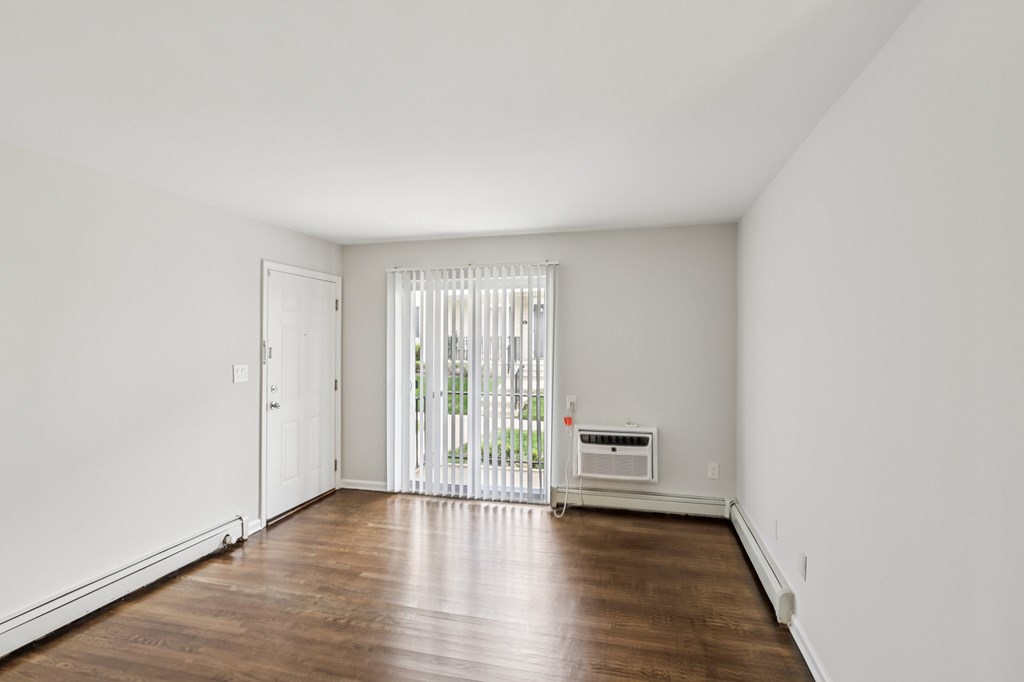 A room with a white door and a window with blinds.