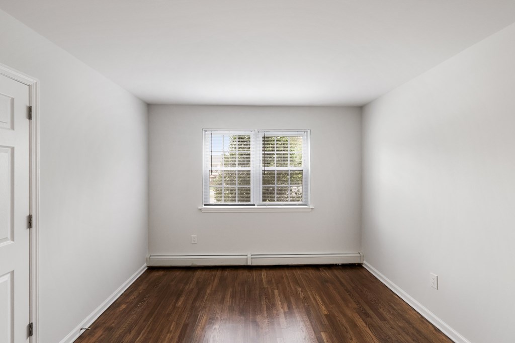 A room with a window and wooden floors.