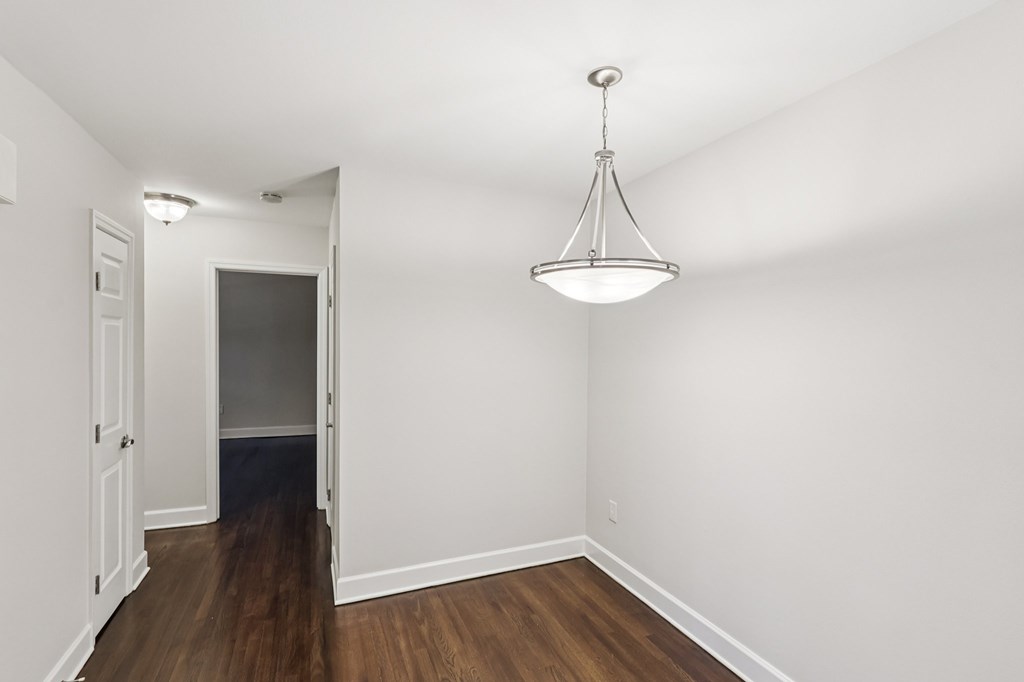 A room with a wooden floor and a hanging light fixture.