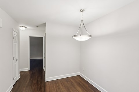 A room with a wooden floor and a hanging light fixture.
