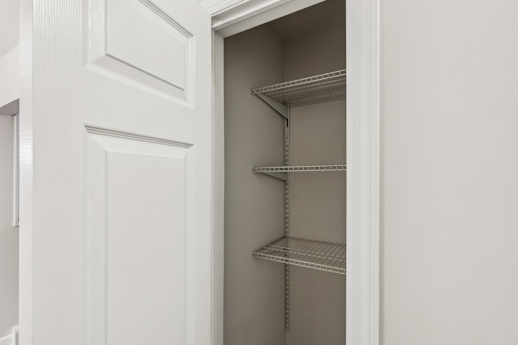 Empty shelves in a white pantry.