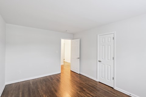 A room with white walls and a wooden floor.