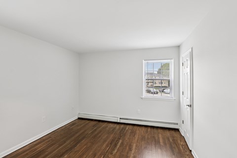 A room with white walls and a picture hanging on the wall.