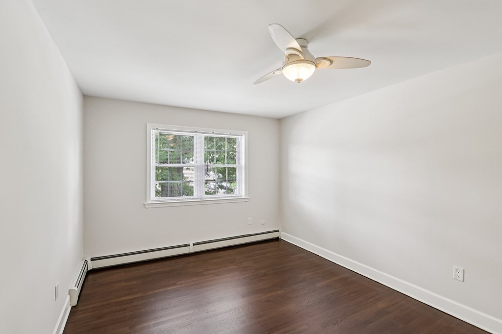 A room with a ceiling fan and a window.
