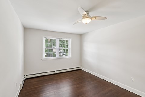 A room with a ceiling fan and a window.