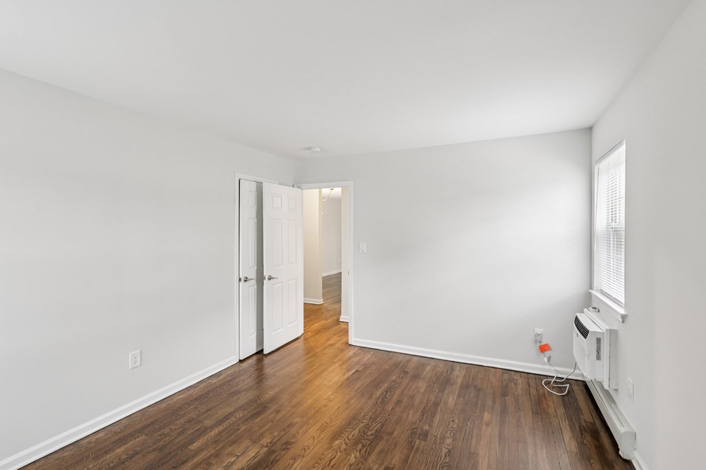 A room with a wooden floor and white walls.