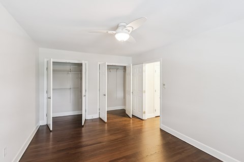 A room with a ceiling fan and open doors.