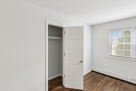 A room with a white door and a window with blinds.