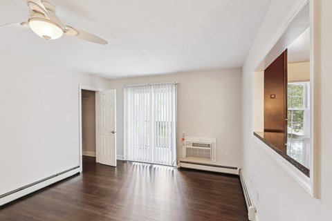 A room with a ceiling fan and a window with blinds.